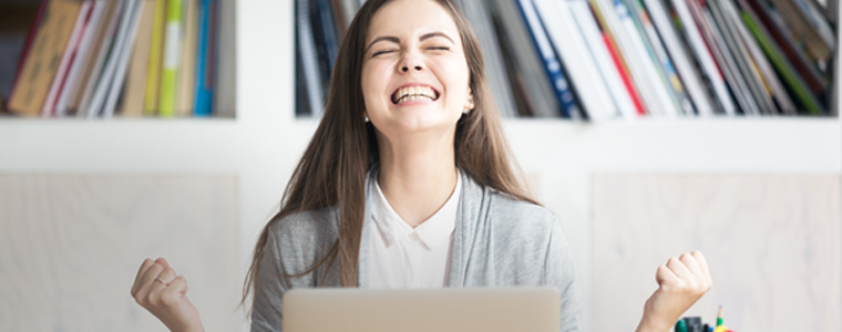happy woman cheering at desk