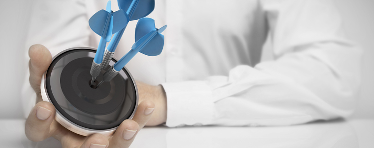 man holding target with darts