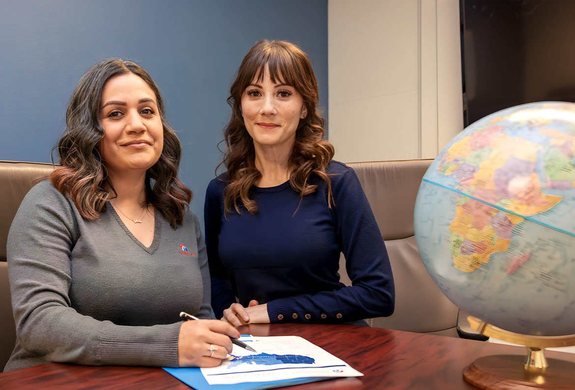 two managers in a conference room with globe and paperwork