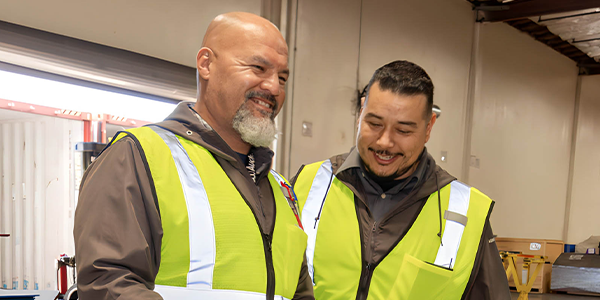 two warehouse workers smiling